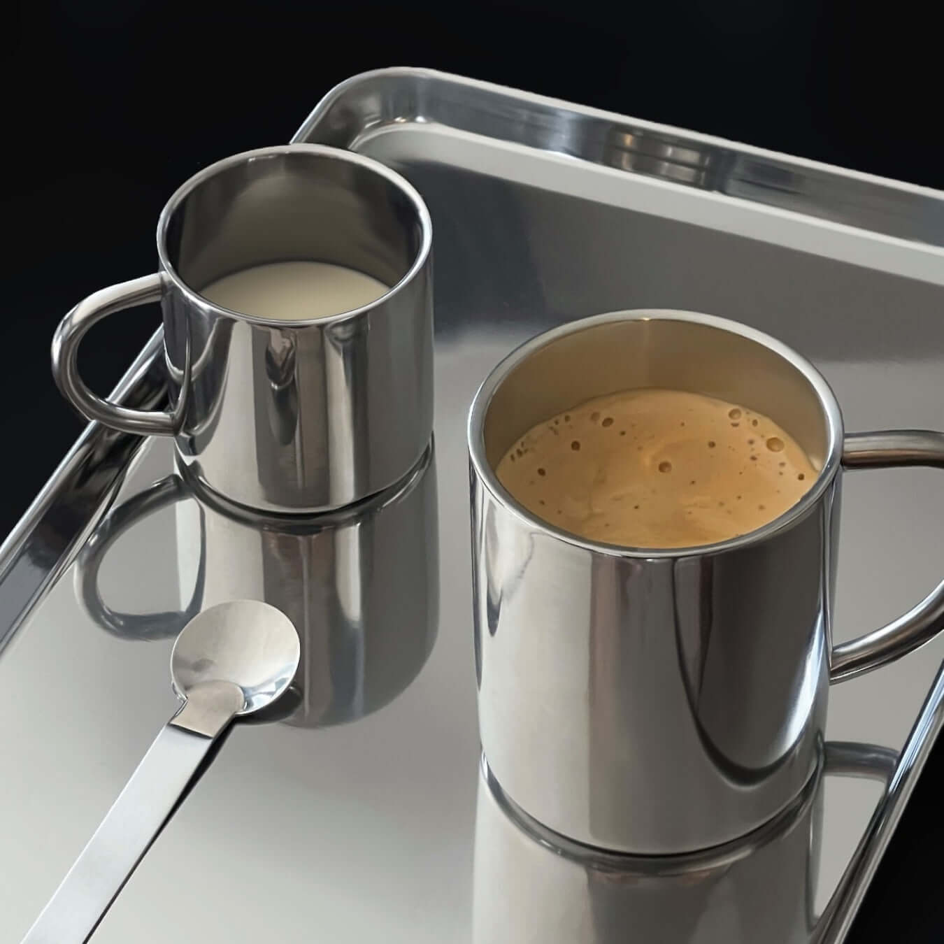 Double-layer glossy stainless steel cups on a marble surface, ideal for keeping beverages at the perfect temperature.
