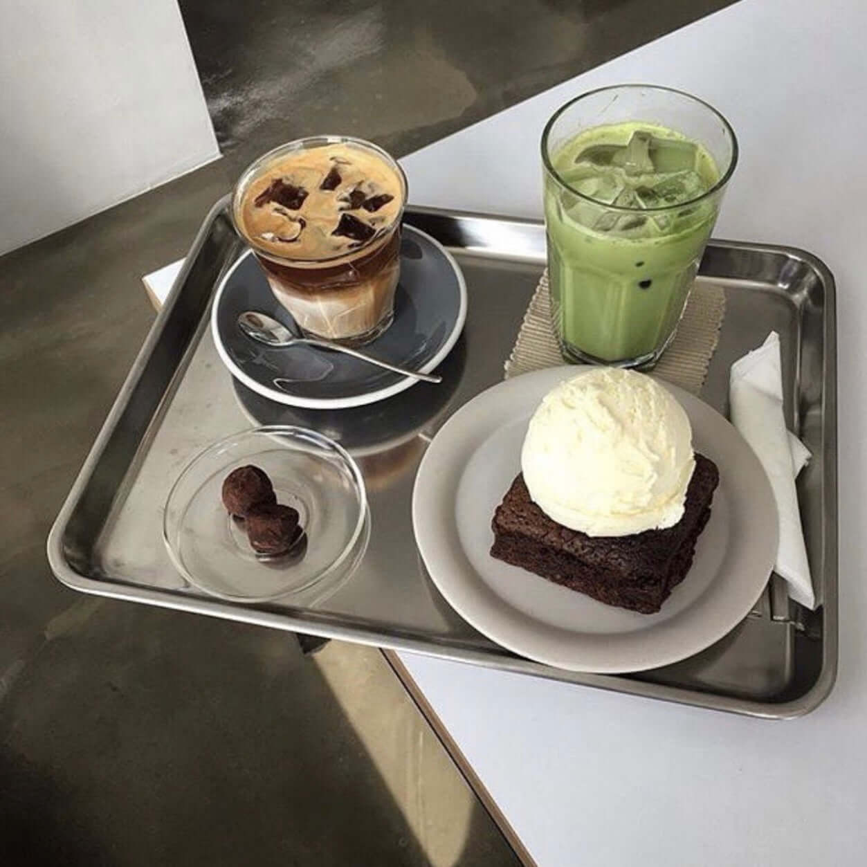 Minimalist stainless steel serving tray displaying slices of lemon pound cake, showcasing modern elegance and functionality.